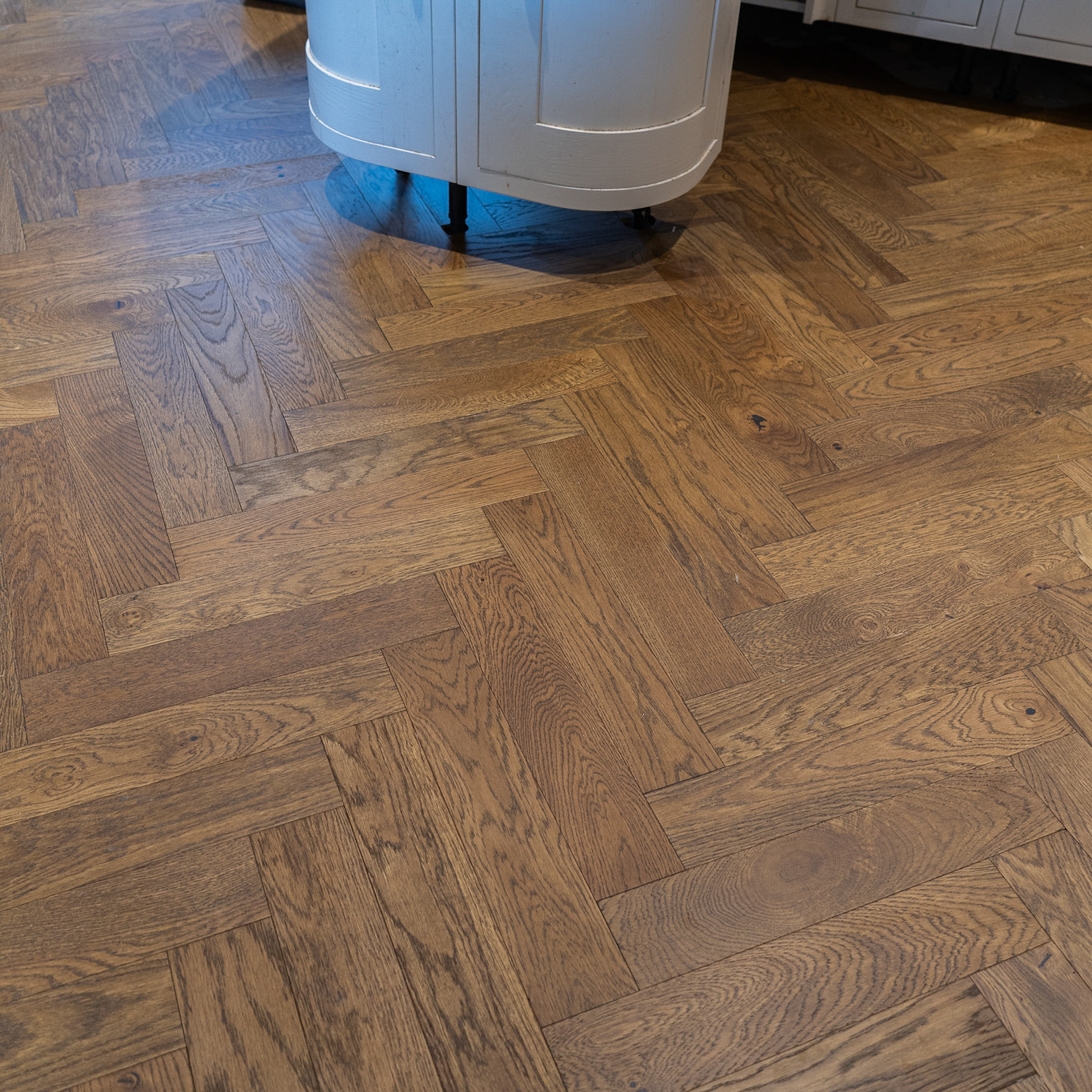 Golden Smoked Oak Herringbone Engineered Wood Flooring with warm golden-brown tones, a rich wood grain texture, and a classic herringbone pattern