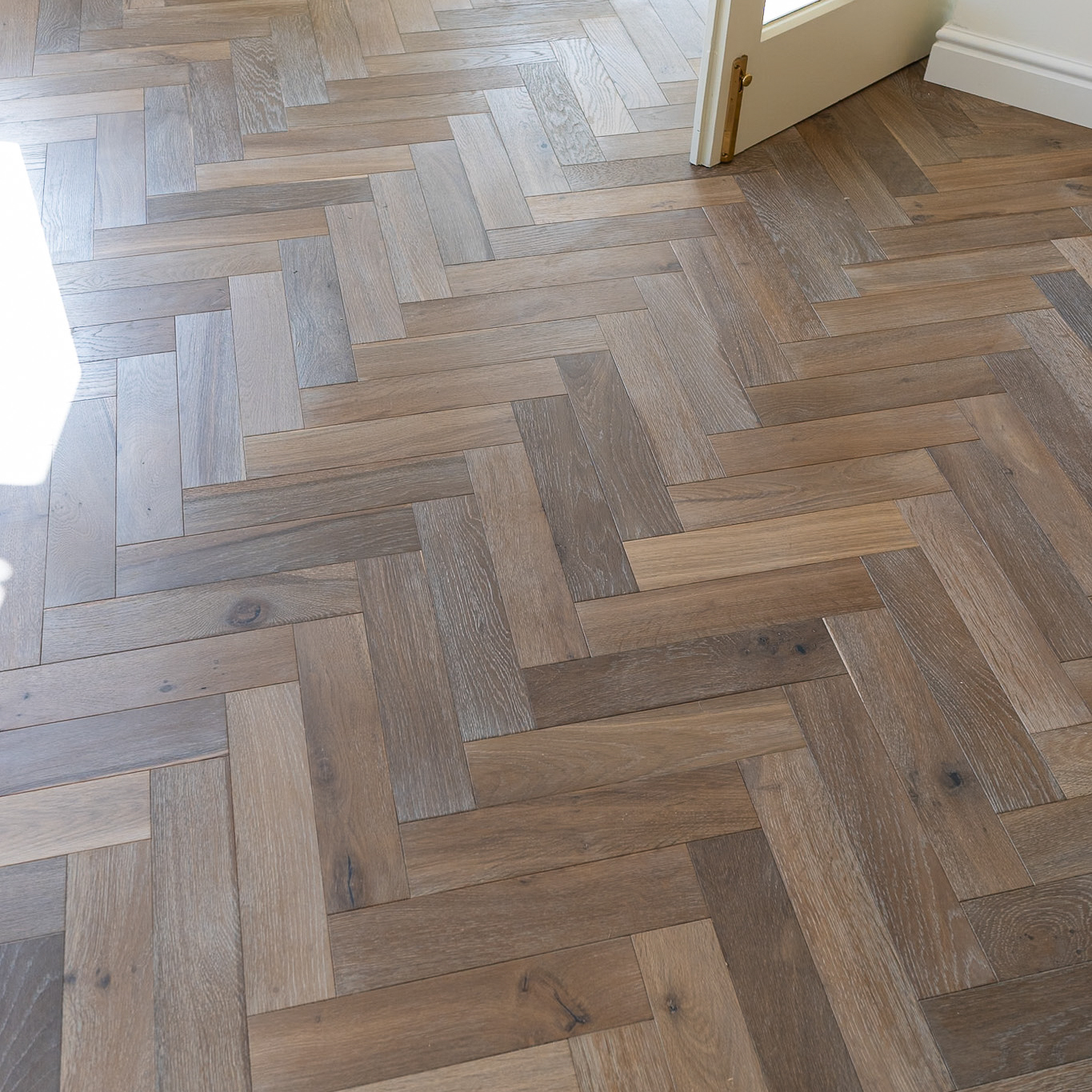 Trade 12mm Smoked Washed Grey Oak Herringbone Engineered Wood Flooring with soft grey tones and a classic herringbone pattern